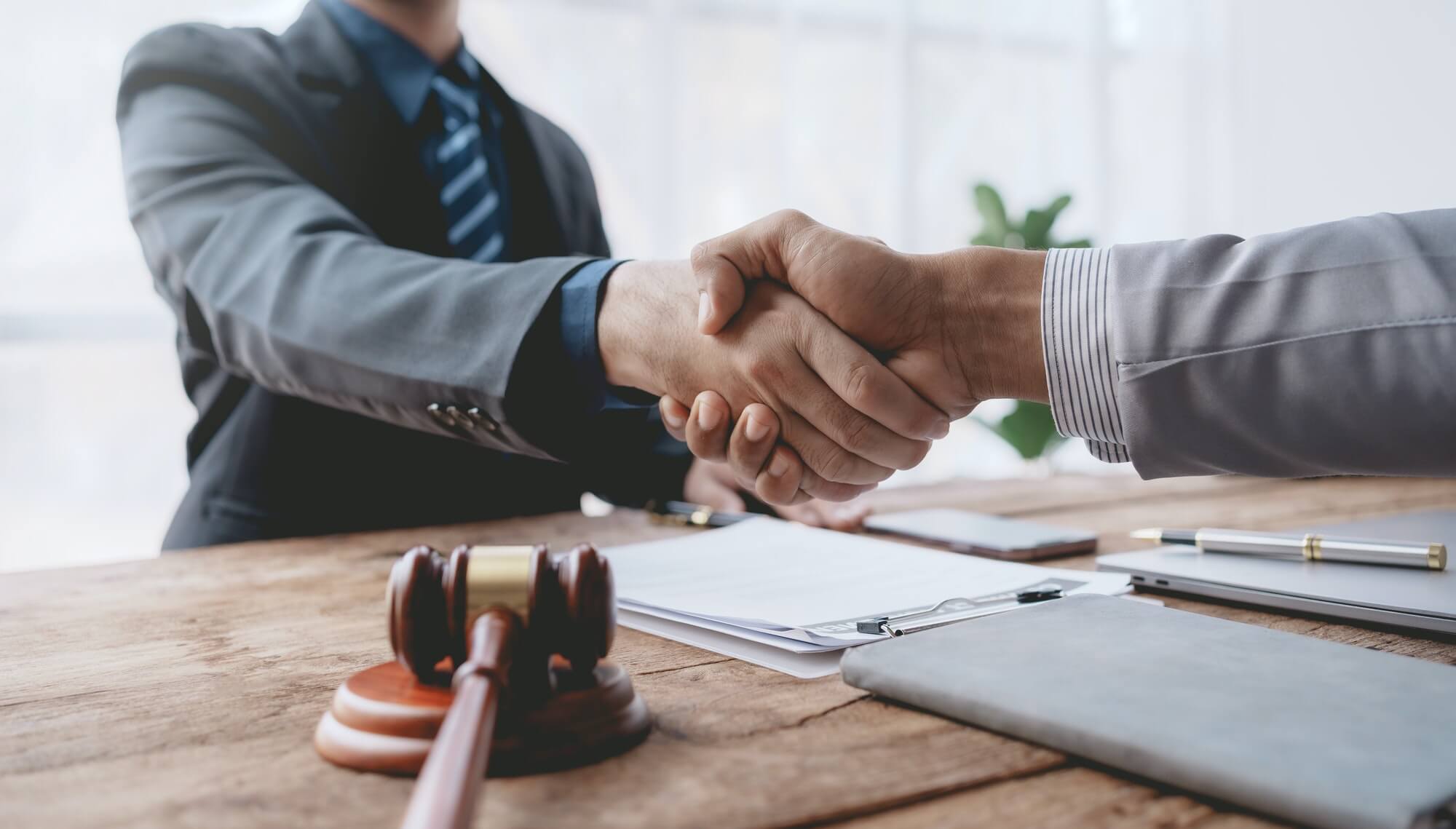 Businessman handshake to seal a deal with his partner lawyer or attorney discussing a contract