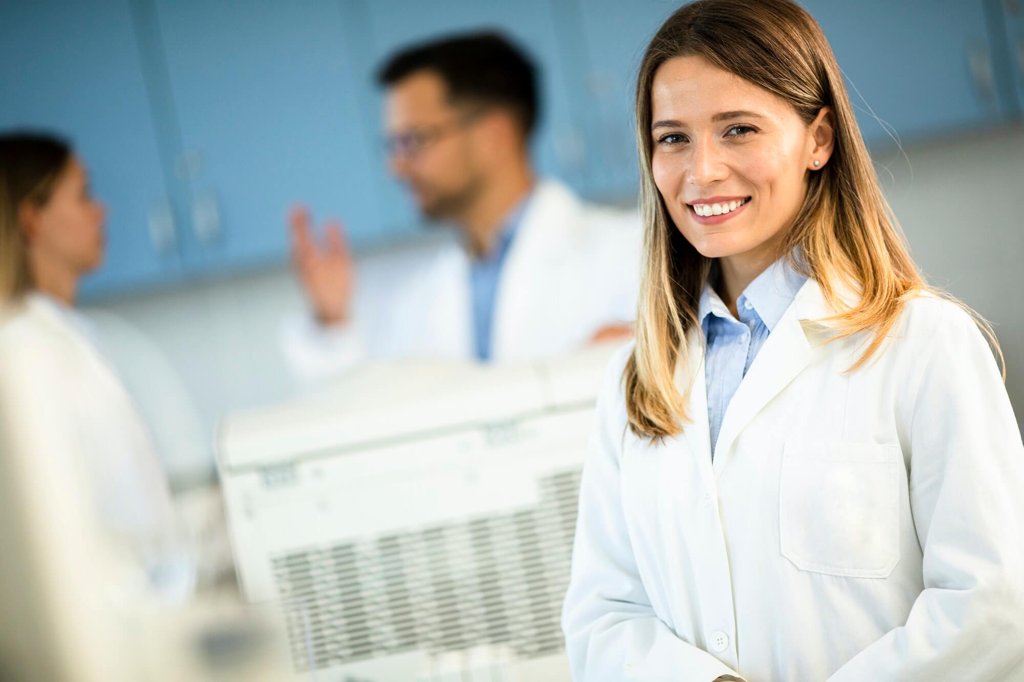 Female scientist in white lab coat standing in the biomedical lab