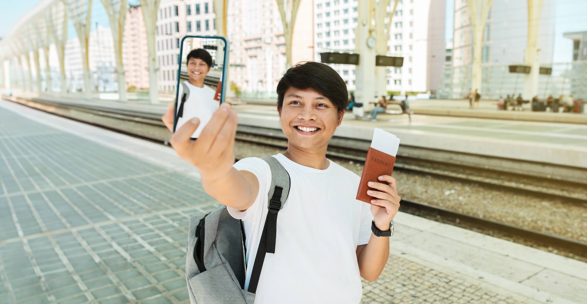 Happy young chinese guy travel blogger taking selfie, showing tickets