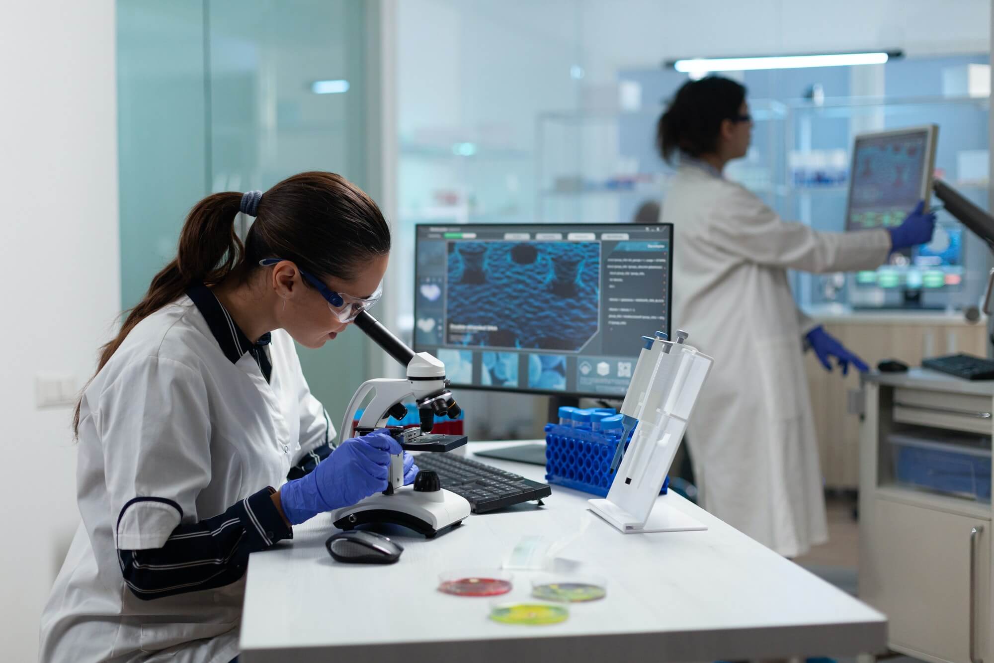 Specialist biologist researcher analyzing biomedical virus sample using medical microscope