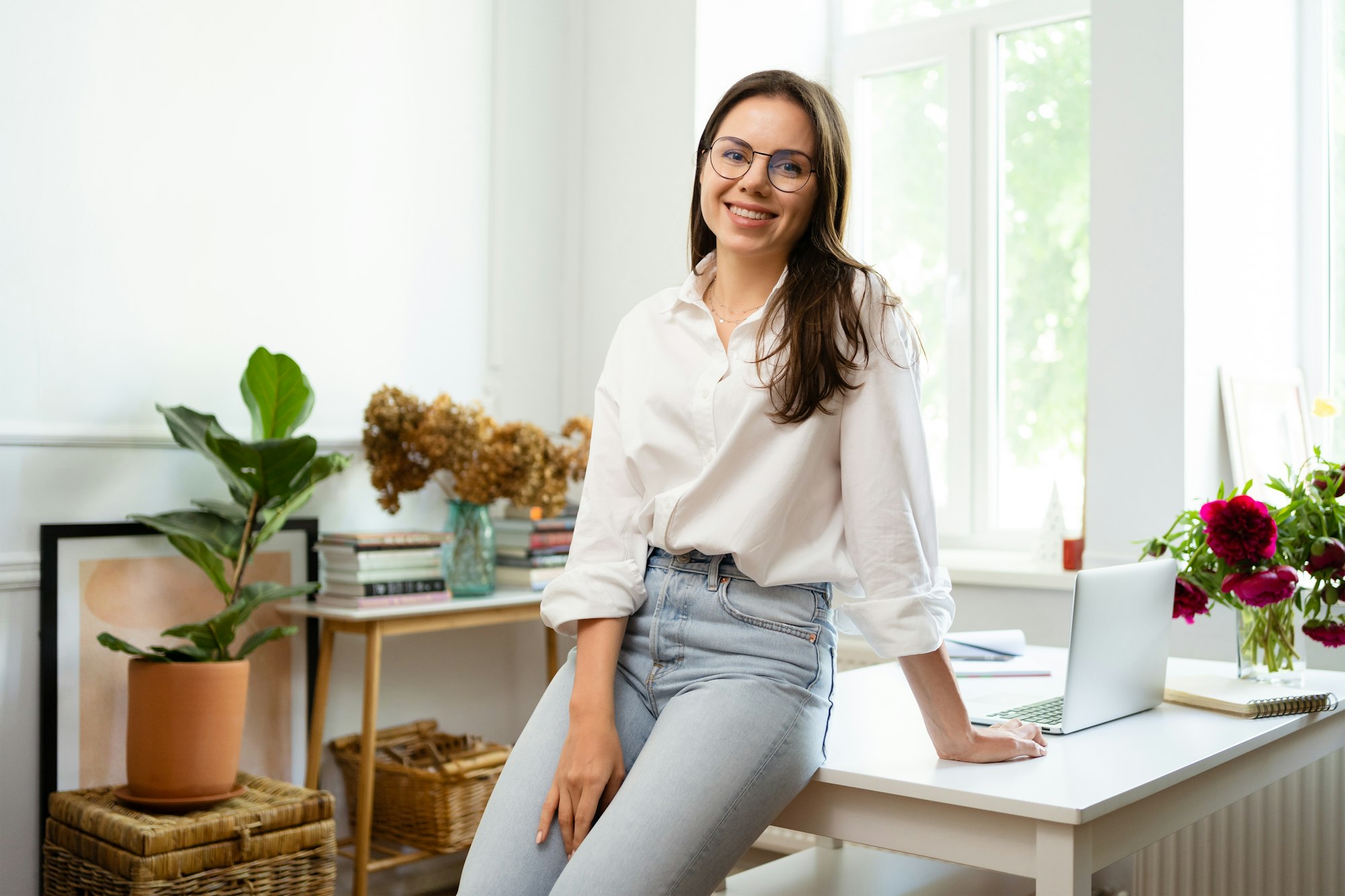 Businesswoman working on laptop computer sitting at home and managing her business via home office