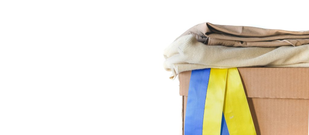 Donations Ukraine, volunteering, charity, war refugees. Girl collects clothes charity for