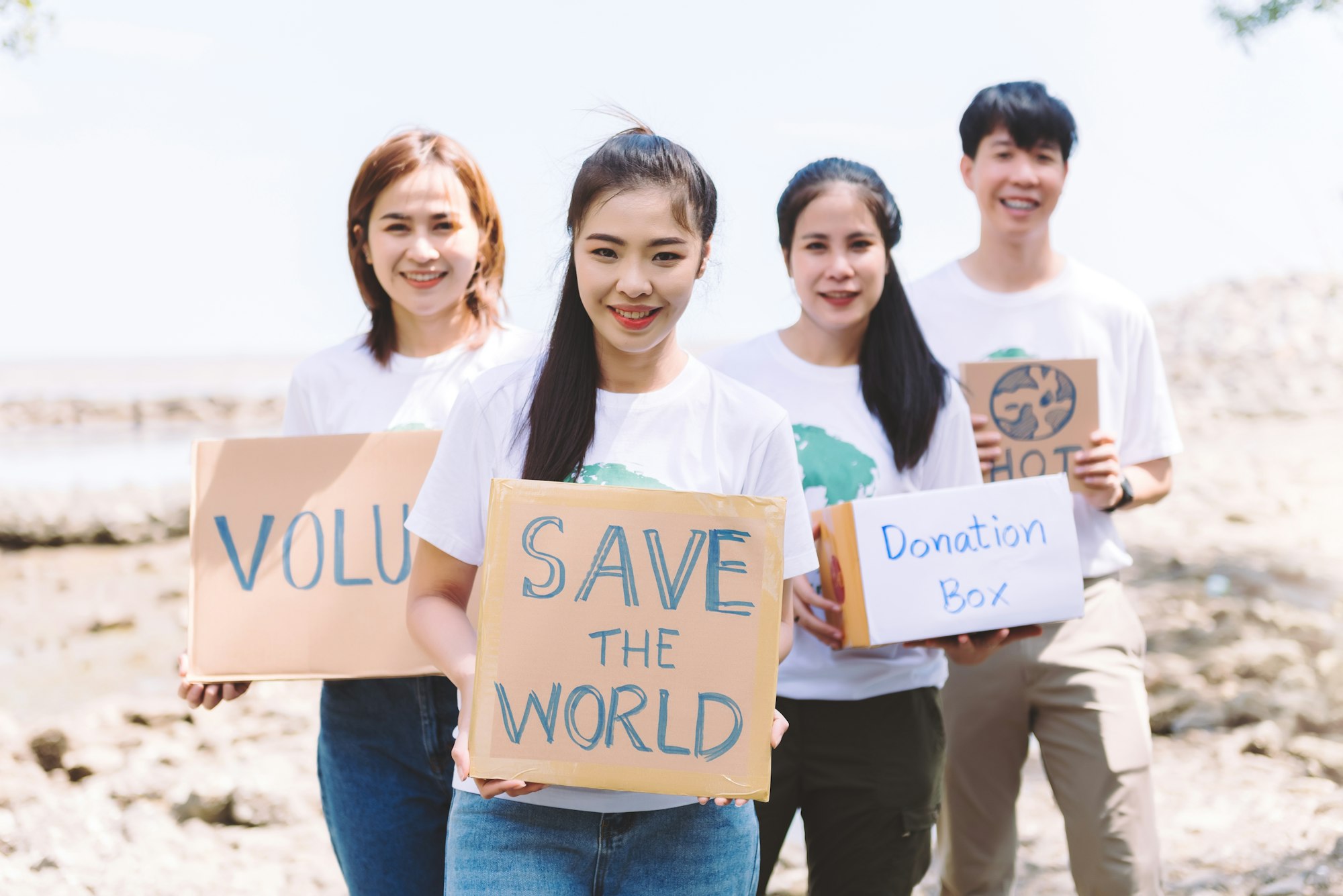 Group of volunteers hold a volunteer sign in world environment day event.