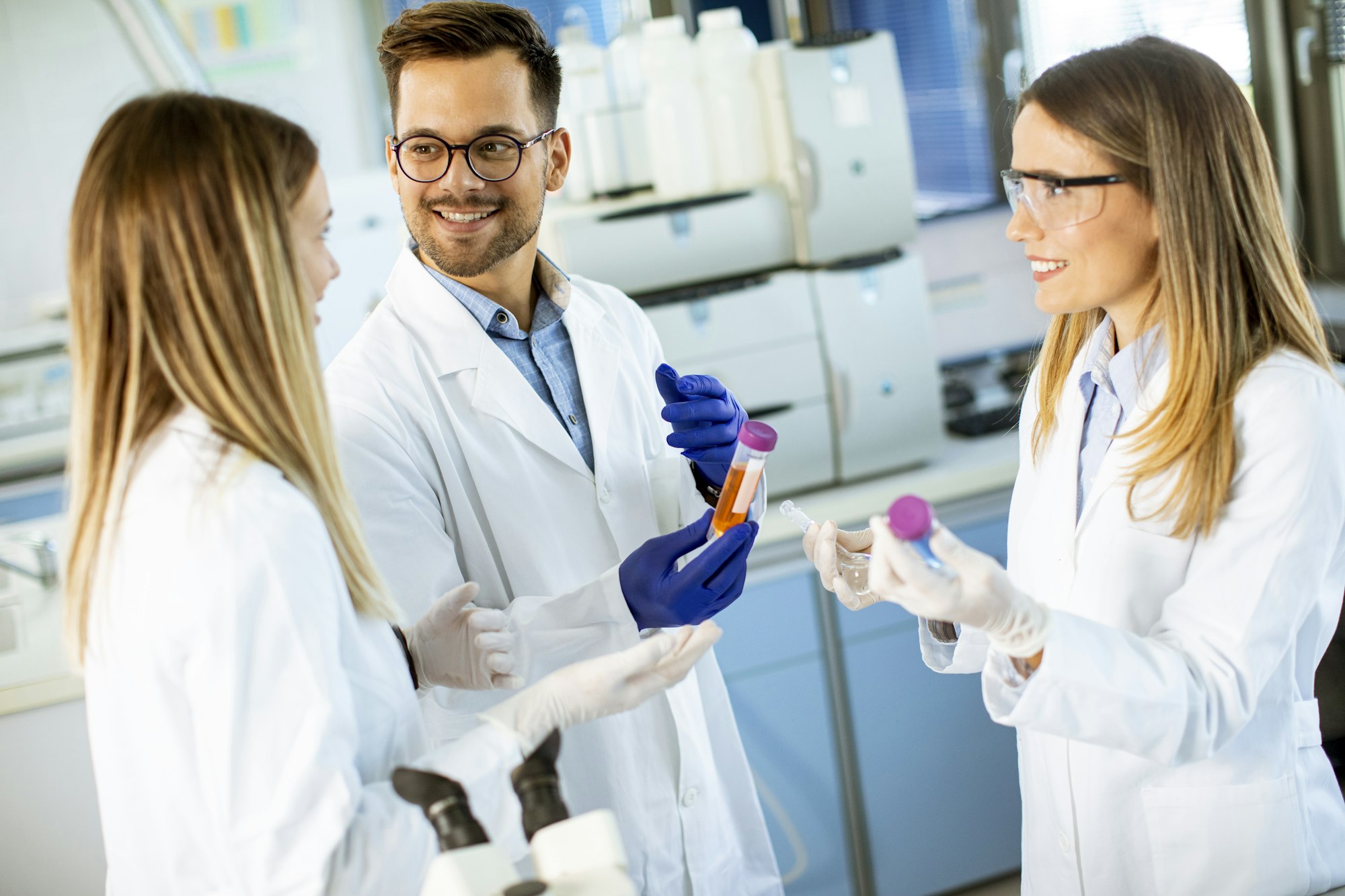 Group of young researchers analyzing chemical data in the laboratory