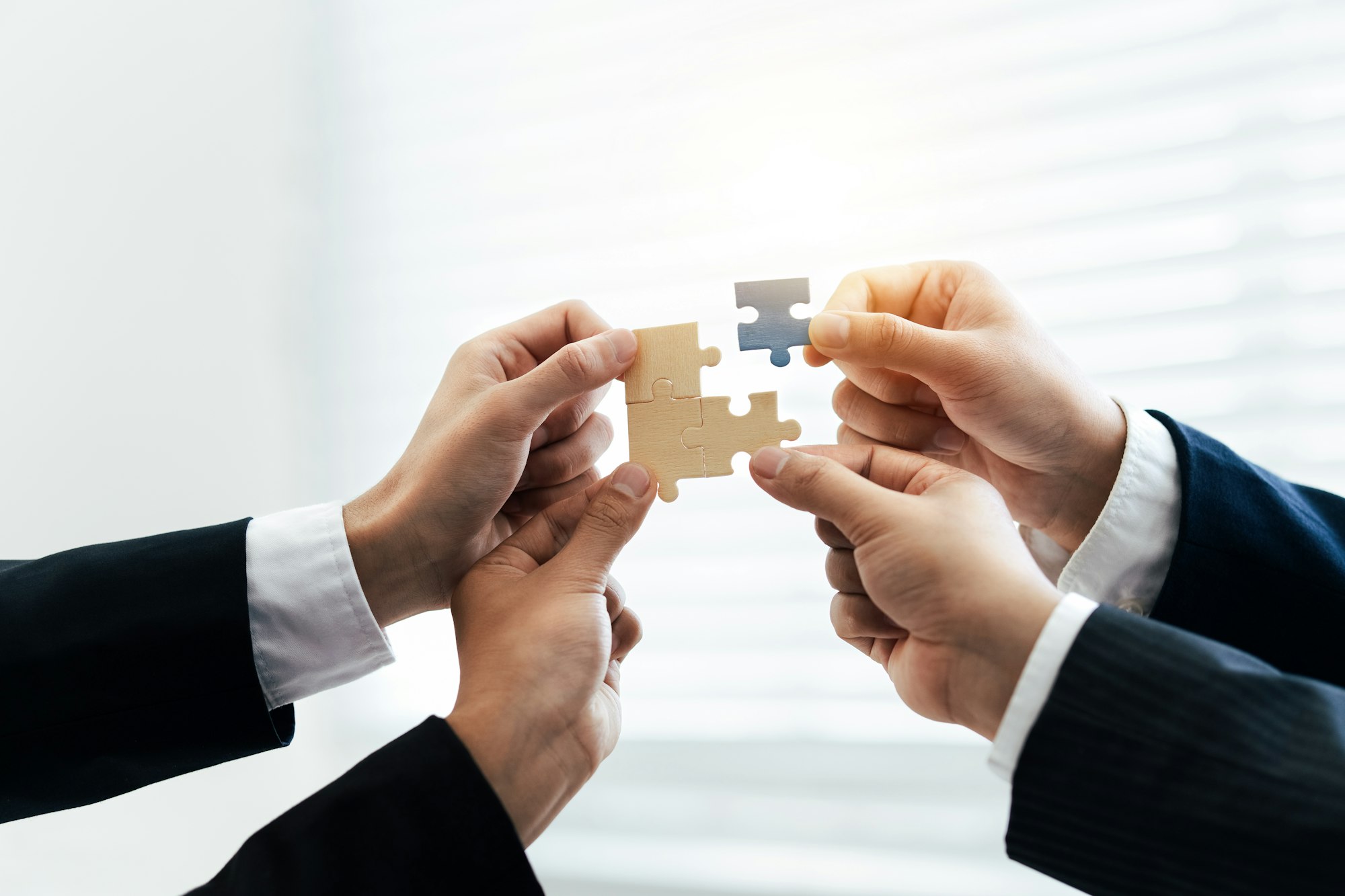 Office workers hold a jigsaw puzzle, teamwork and unity. Charity, volunteering, problem solving