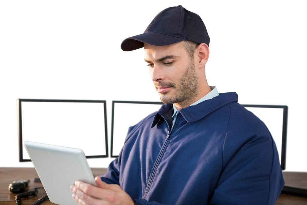 Security officer using digital tablet at desk