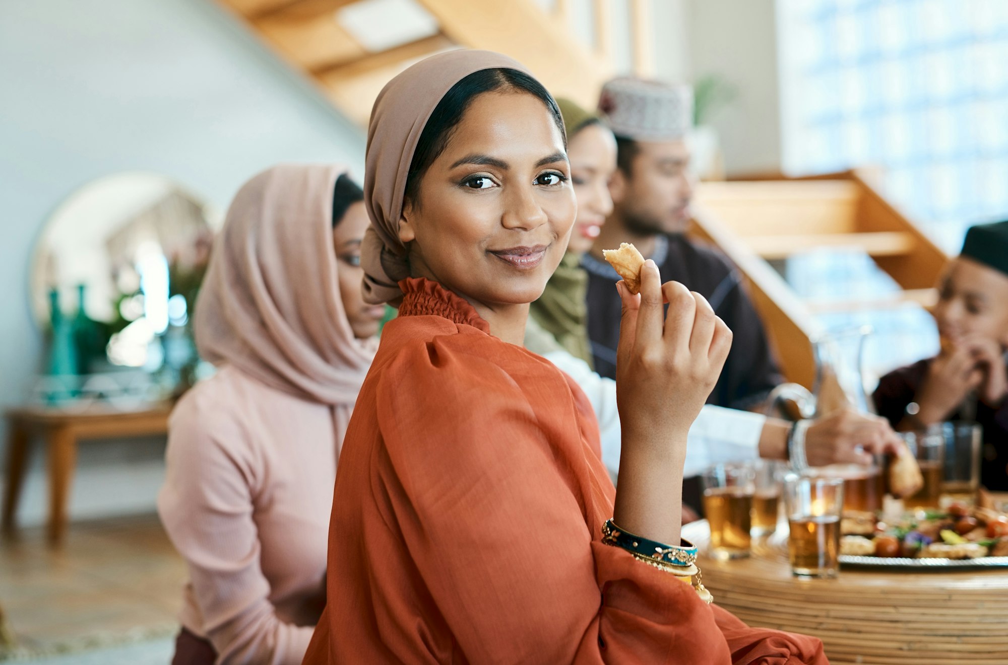 Sharing a meal with others is special. Shot of a young muslim woman enjoying lunch with her family.