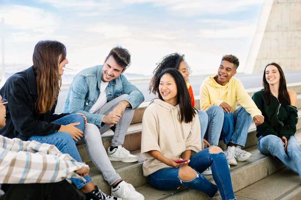 United group of young college friends talking together outdoor